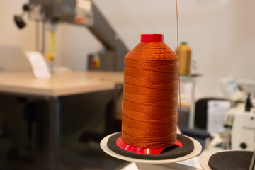 Close up photo with selective focus of sewing spool of thread in sewing workshop