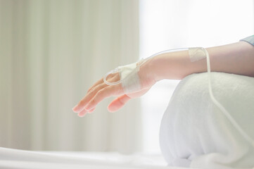 Drop of saline solution drip into patients arm in the hospital.