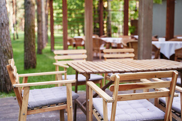 Outdoor cafe, patio wooden furniture.
