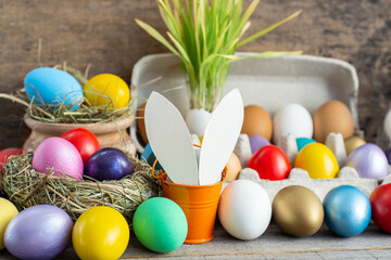 multi colors painted easter eggs in decor nest. Happy Easter holiday card	
