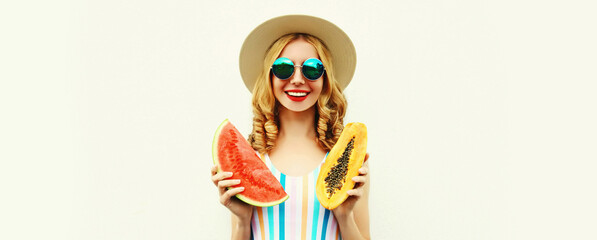 Summer portrait of happy smiling young woman with slice of watermelon and papaya wearing straw hat, sunglasses, on white background
