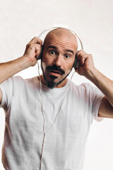 Surprised man wearing headphones. Photograph on white background, person with beard and mustache