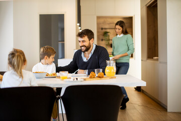 Young mother preparing breakfast for her family in the kitchen