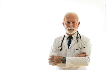 Portrait of senior professor standing in front of white background with arms crossed and smiling.