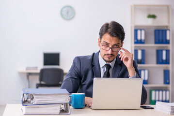 Young male employee sitting at workplace