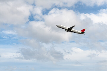 Naklejka na ściany i meble Airplane taking off, aircraft in blue sky