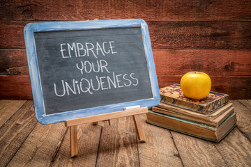 embrace your uniqueness - white chalk writing on a retro slate blackboard, being different and personal development concept