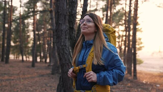 Girl travels through the natural park on foot. Hiking in woods. Girl tourist hike with backpack. Summer adventure, vacation freedom. Woman travels outdoors with a backpack. Hiking in the mountains
