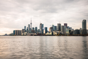 Fototapeta premium View of Toronto skyline under cloudy sky at sunset in autumn