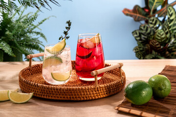 Sparkling cocktails with ice and citrus on a wicker tray. Popular bright refreshing alcohol drinks. Refreshing summer beverages.