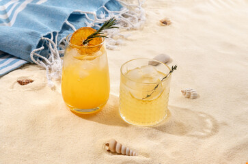 Selection of summer alcoholic cocktails on a wicker tray on beach with white sand. Summer sea...