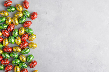 Colorful Easter eggs on a grey background with space for text, top view, flat lay. Easter festive background