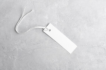 Rectangle strip white tag mockup with white cord, close up. Blank paper rectangular price tag...