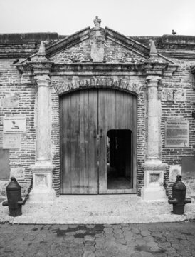 Dramatic black and white image of a museum in the colonial district of Santo Domingo,Dominican Republic, with weathered stone and wood.