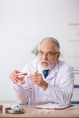 Old male doctor dentist working in the clinic