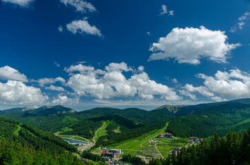 Fototapeta premium Magnificent panoramic view the coniferous forest on the mighty Carpathians Mountains and beautiful blue sky background. Beauty of wild virgin Ukrainian nature. Peacefulness.