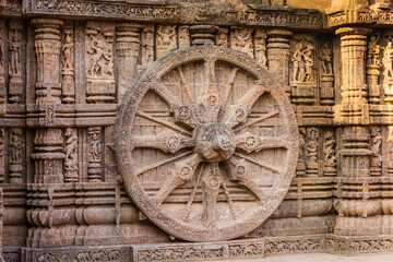 Fototapeta na wymiar A stone wheel engraved in the walls of the 800 year old Sun Temple, Konark, India. The temple is designed as a chariot consisting of 24 such wheels.