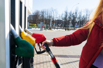 Close-up of a young woman's hand holding a refueling gun