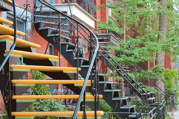Colored houses outdoor staircase in Montreal, Plateau Mont Royal neighborhood during housing crisis...