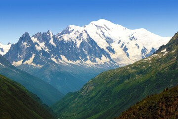 Le massif du Mont Blanc au dessus d'une vallée dans les Alpes.