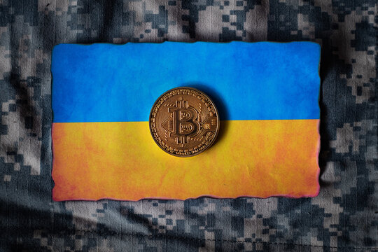 Bitcoin token on Ukrainian flag, Dark grunge military camouflage background abstract,