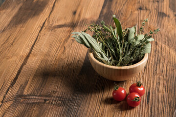 Various herbs on rustic table and tomatos