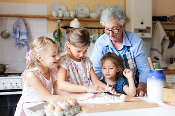 Family cooking class at home. Grandmother and kids have fun in kitchen