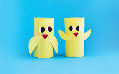 Fototapeta premium Holiday easy DIY craft idea for kids. Toilet paper roll tube toy's cute chick on blue background. Creative Easter, Christmas decoration eco-friendly, reuse, recycle handmade minimal concept