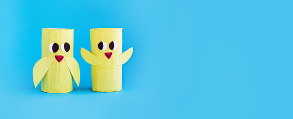 Holiday easy DIY craft idea for kids. Toilet paper roll tube toy's cute chick on pink background banner. Creative Easter, Christmas decoration eco-friendly, reuse, recycle handmade minimal concept