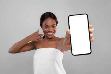Fototapeta na wymiar Beautiful Young Black Female Wrapped In Bath Towel Demonstrating Big Blank Smartphone