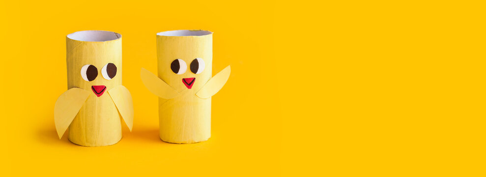 Holiday easy DIY craft idea for kids. Toilet paper roll tube toy's cute chick on pink background banner. Creative Easter, Christmas decoration eco-friendly, reuse, recycle handmade minimal concept