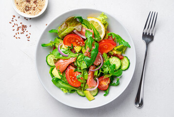Vegetable salad with salmon, fresh herbs and sesame and flax seeds.