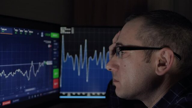 A thoughtful businessman man looks at the investment schedule on the monitor. Financial development, bank account, statistics. Financial stock market. Investments in the stock market.