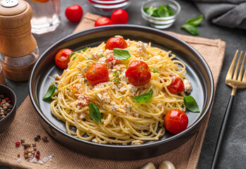 Pasta with feta cheese and cherry tomatoes on a dark background.