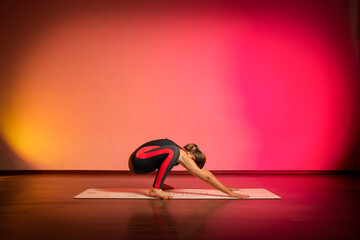 A woman doing yoga exercise on a colored background