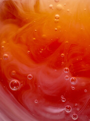 Yellow and orange background with bubbles and a pattern made with liquid soap, vertical image,...