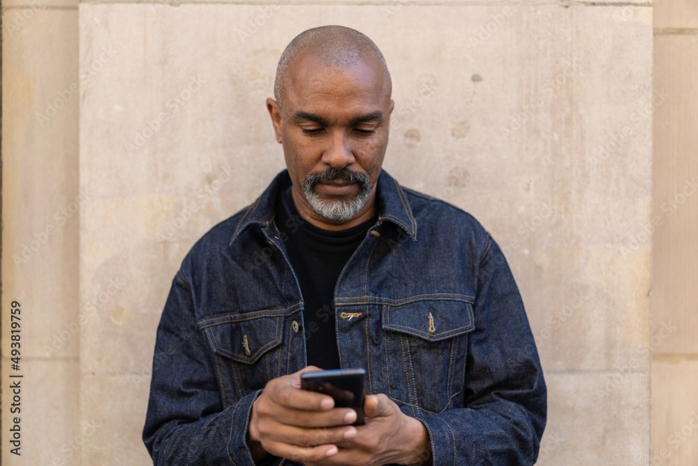 Canvas Prints Mature black man in city using cell phone