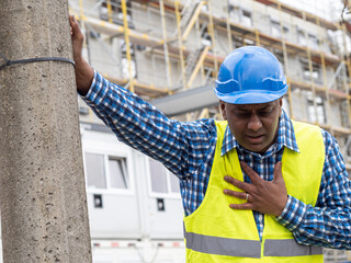 Indian or somali construction worker having a heart attack on work outdoors