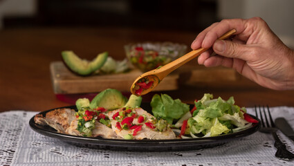 Hand putting sauce on traditional ecuadorian dish 