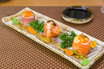 Platter decorated with different flavors of elegant sushi.