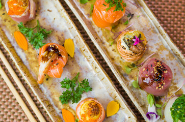 Platter decorated with different flavors of elegant sushi.