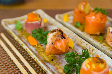 Platter decorated with different flavors of elegant sushi.