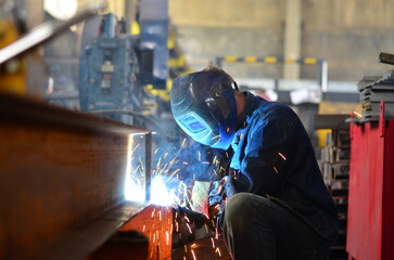 Fototapeta premium A welder works at a factory