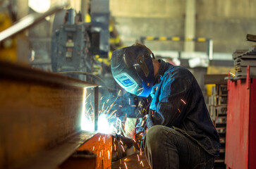 Fototapeta premium A welder works at a factory