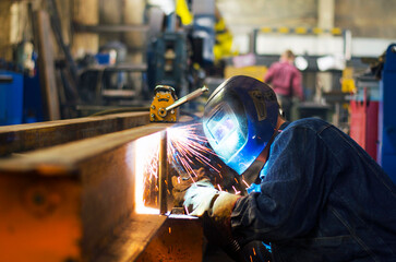 A welder works at a factory
