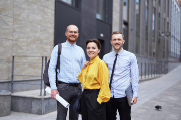 Strong confident professional group of business persons standing outside. Caucasian team of young male and female business executives. Finance, real estate or construction industry concept