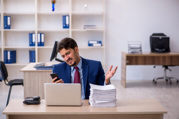 Young businessman employee and too much work in the office