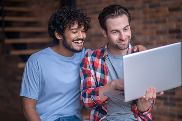 Male freelancer and his boyfriend looking at the computer screen