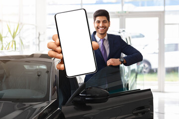 Emotional businessman choosing new car, showing mobile phone, mockup