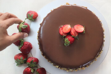 Chocolate cake with chocolate ganache and topped with walnut and fresh strawberries